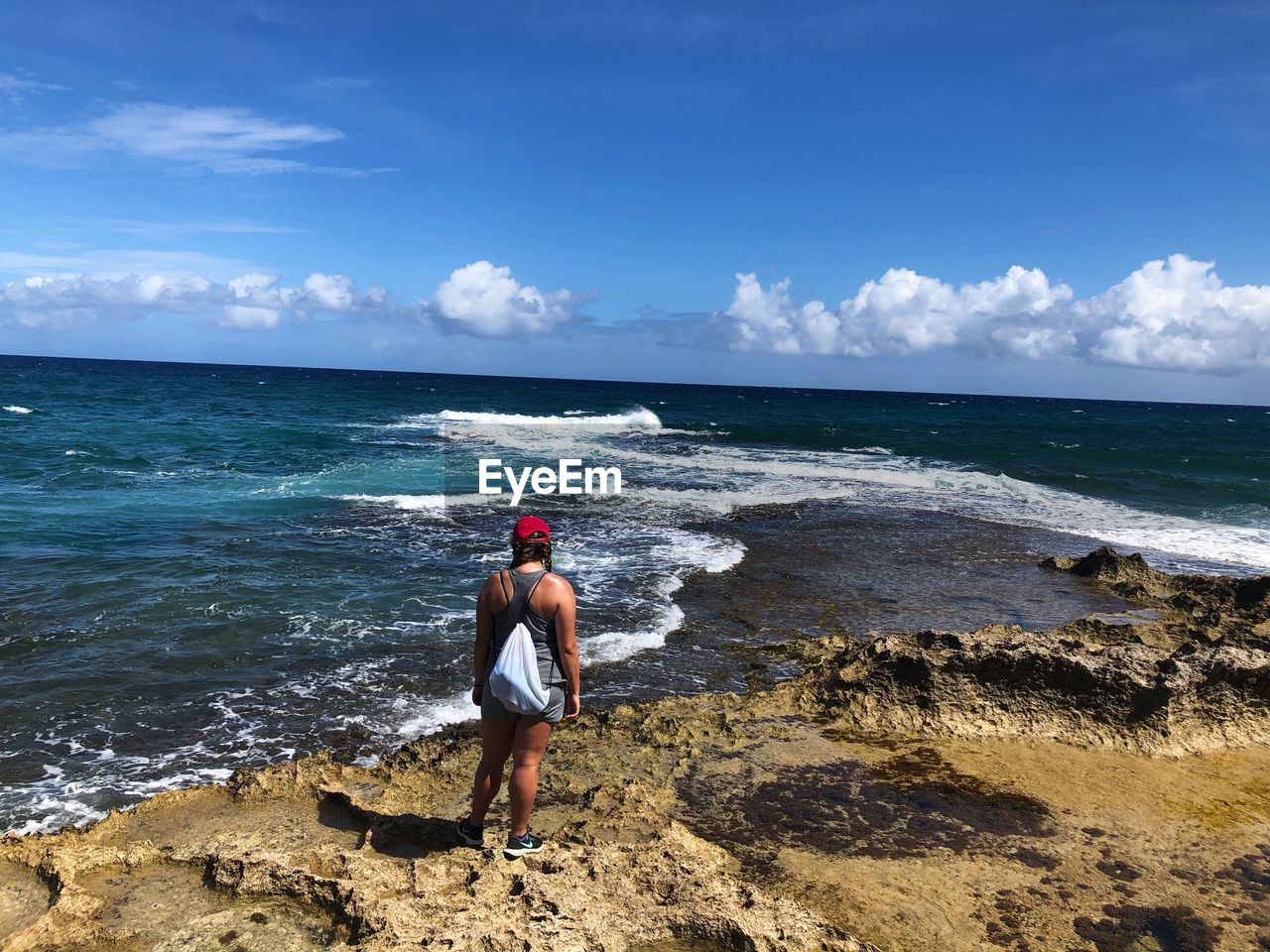 WOMAN LOOKING AT SEA SHORE AGAINST SKY