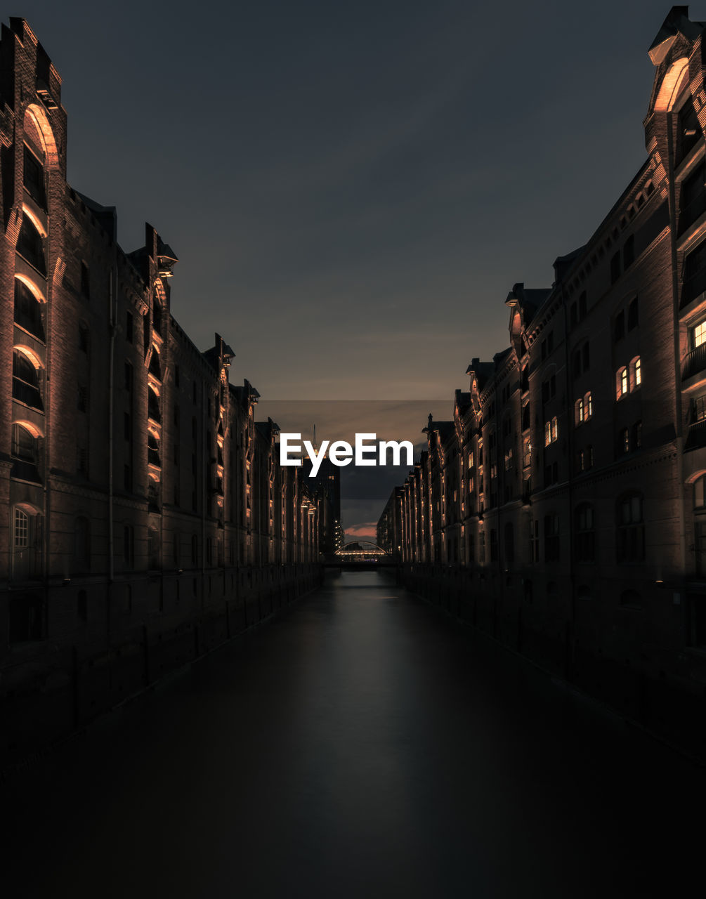 Canal amidst buildings against sky at night