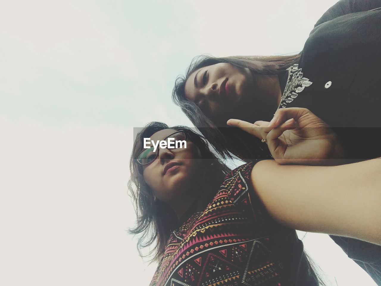 Portrait of young women standing against sky