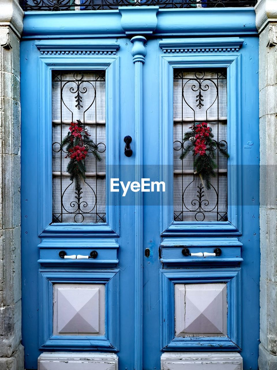 Christmas decoration on sky blue doors. 