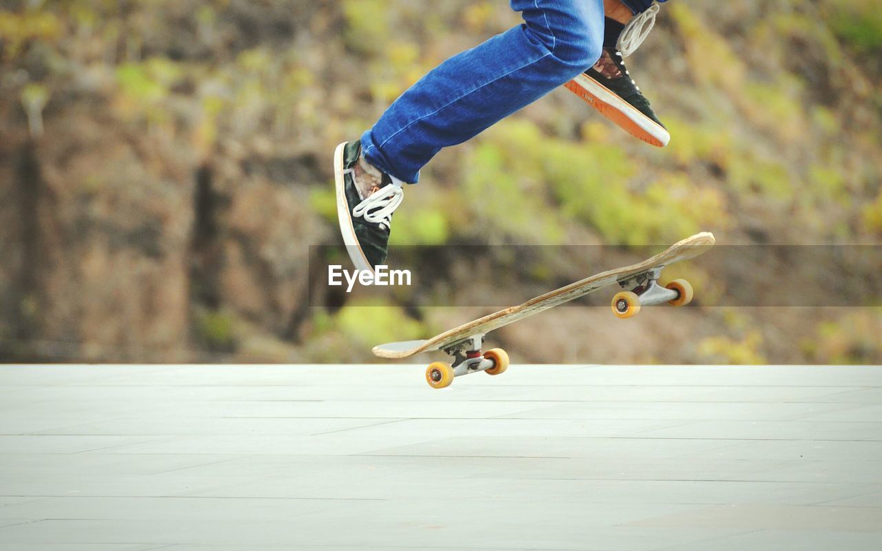 Low section of man skateboarding on road