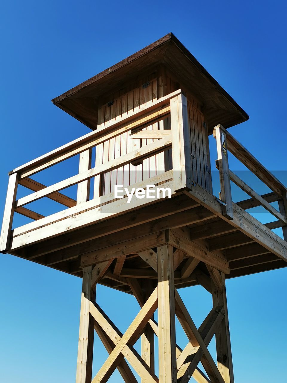 architecture, tower, built structure, sky, observation tower, blue, building exterior, nature, clear sky, no people, man made structure, lifeguard hut, landmark, wood, security, outdoors, lookout tower, protection, observation point, low angle view, building, day, sunny, communication