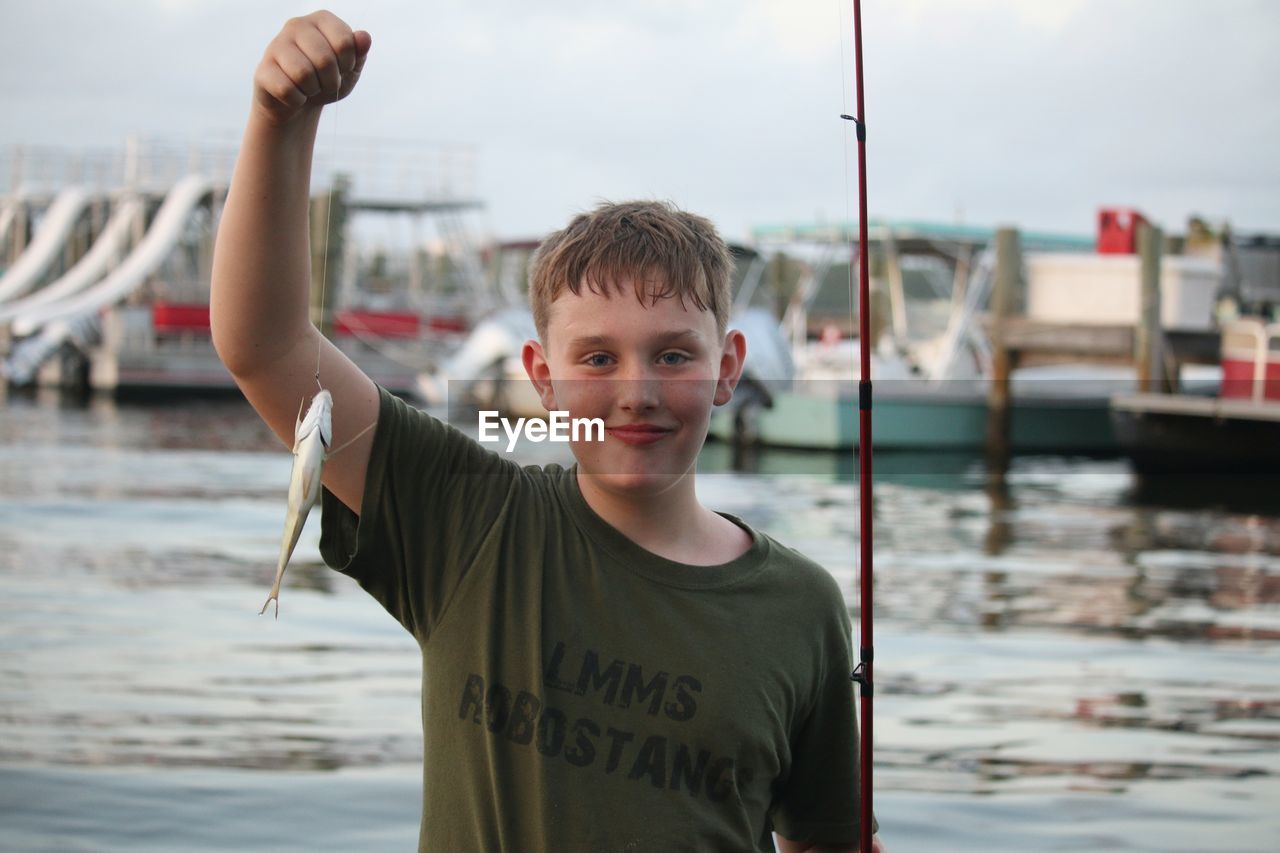 Boy holding caught fish 