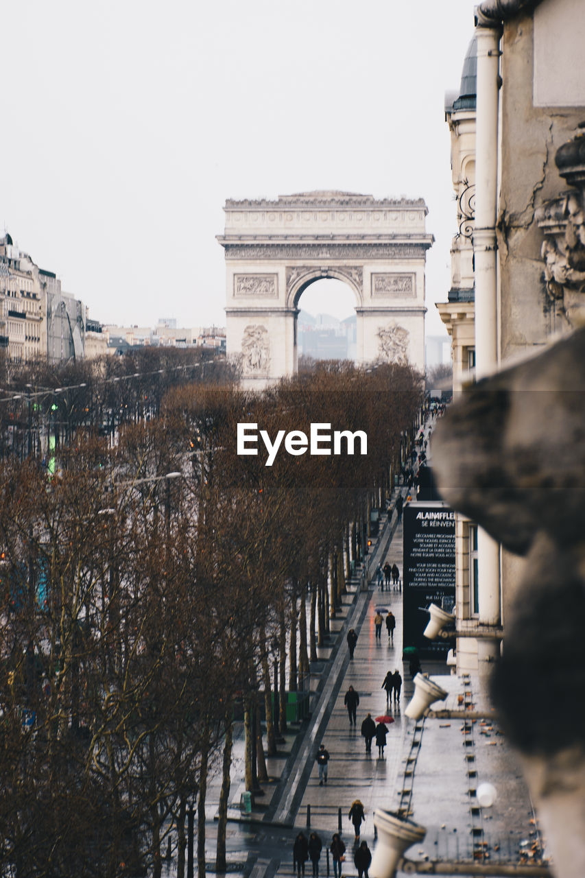 People walking in front of arc de triomphe against sky