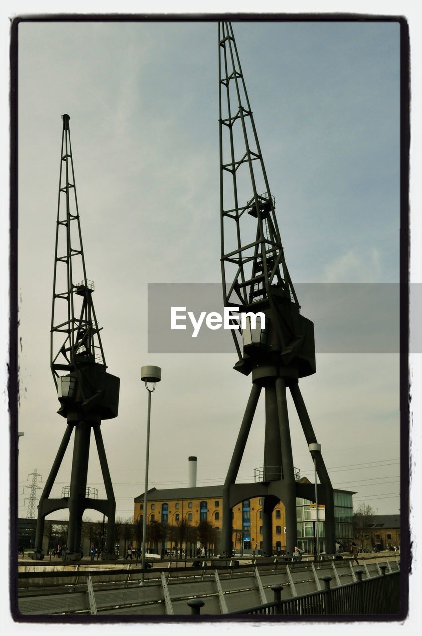 LOW ANGLE VIEW OF CRANES AGAINST SKY