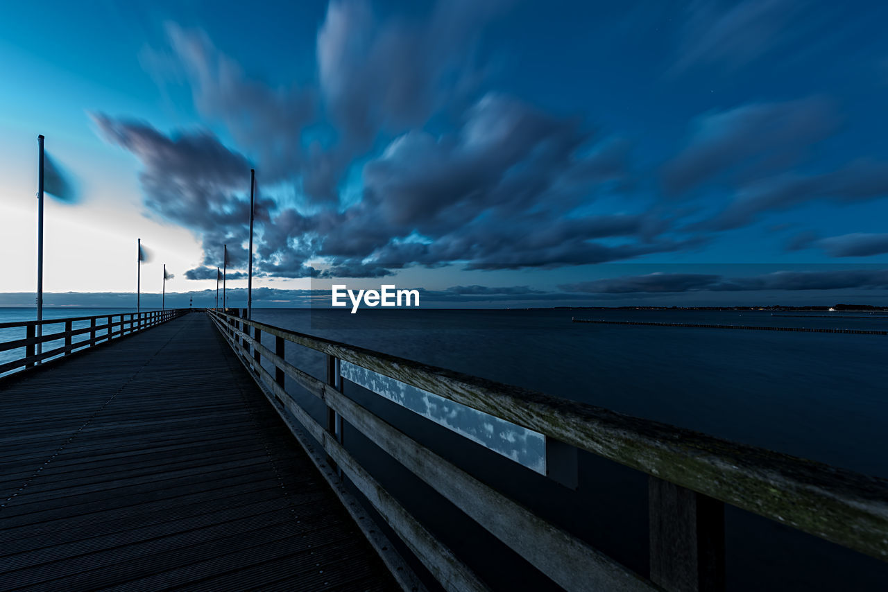 Pier over sea against blue sky