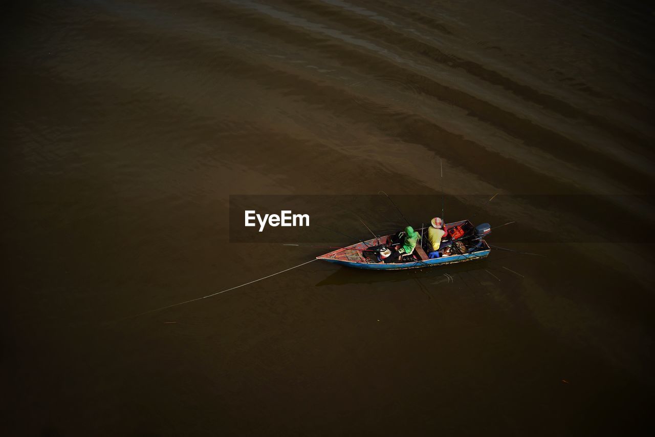 High angle view of fishermen fishing on boat in sea