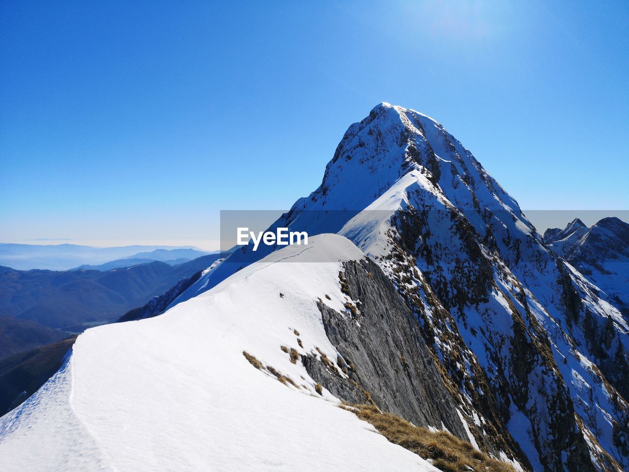Scenic view of snowcapped mountains against clear blue sky