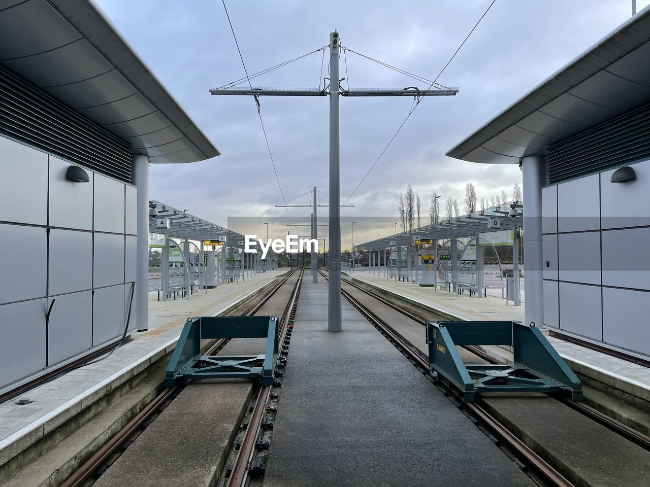 Railroad tracks in city against sky