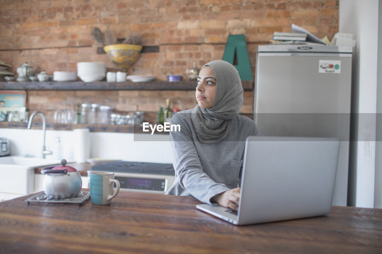 Muslim businesswoman working from home on her laptop