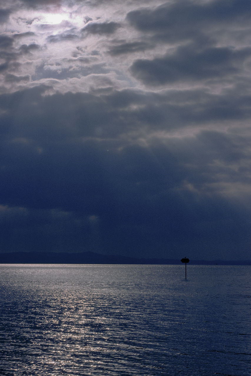 SILHOUETTE OF MAN IN SEA AGAINST SKY