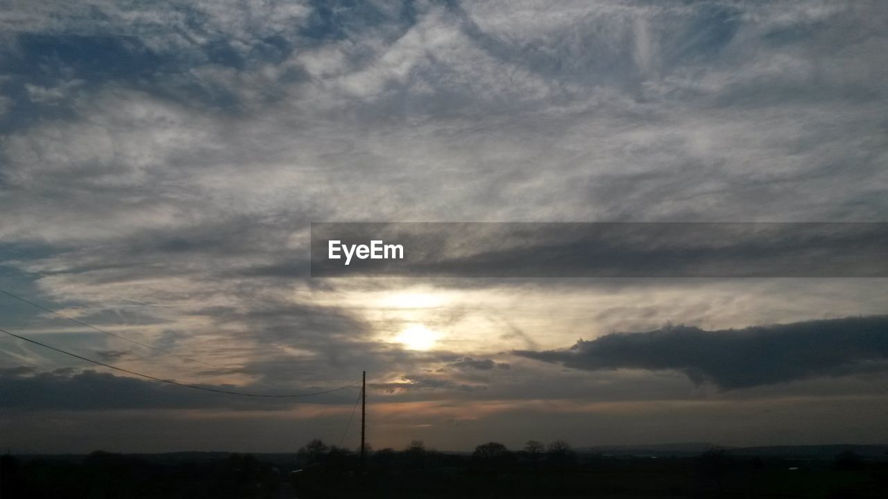 SCENIC VIEW OF LANDSCAPE AGAINST CLOUDY SKY DURING SUNSET