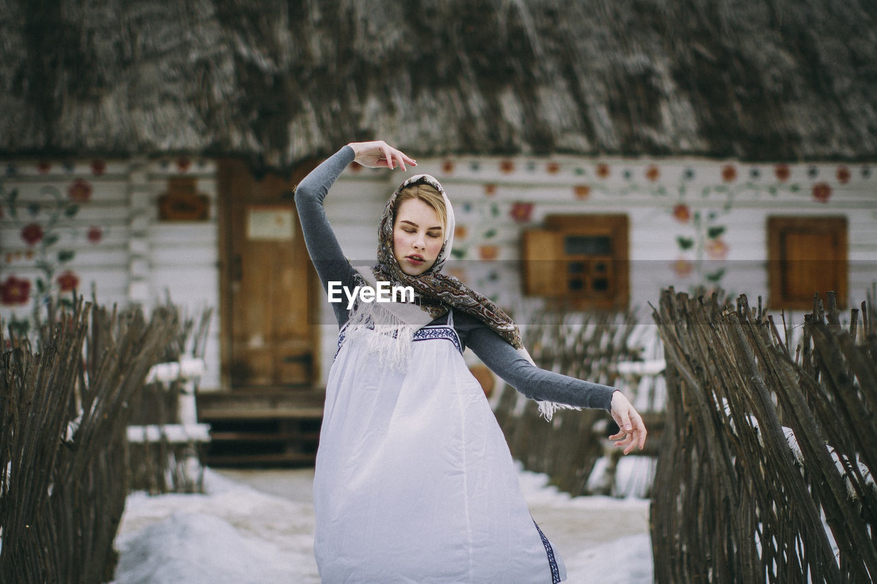Woman with eyes closed standing in snow