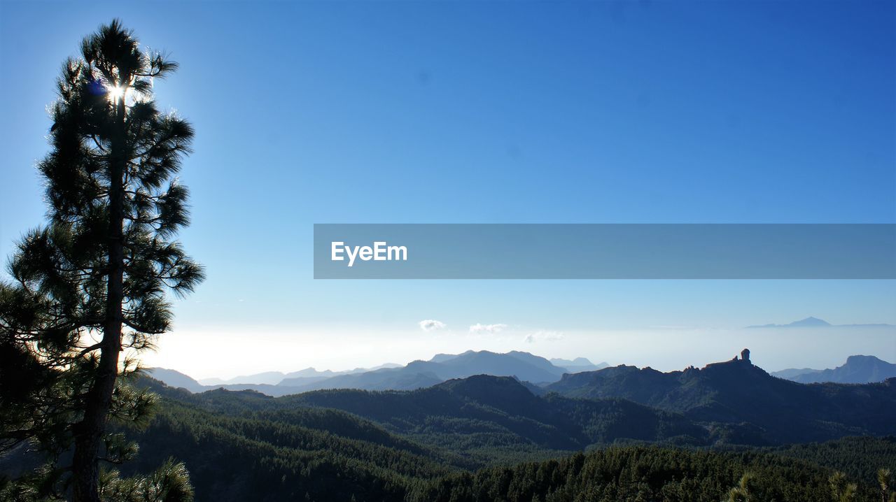 Scenic view of mountains against clear blue sky