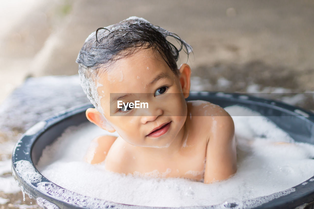 Cute baby girl sitting in tub