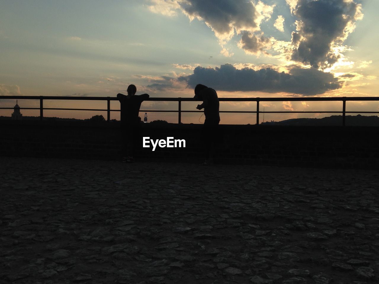 SILHOUETTE OF PEOPLE IN WATER AT SUNSET