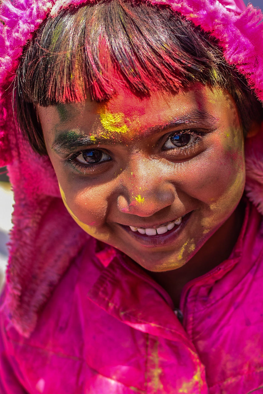 Close-up portrait of smiling girl during holi