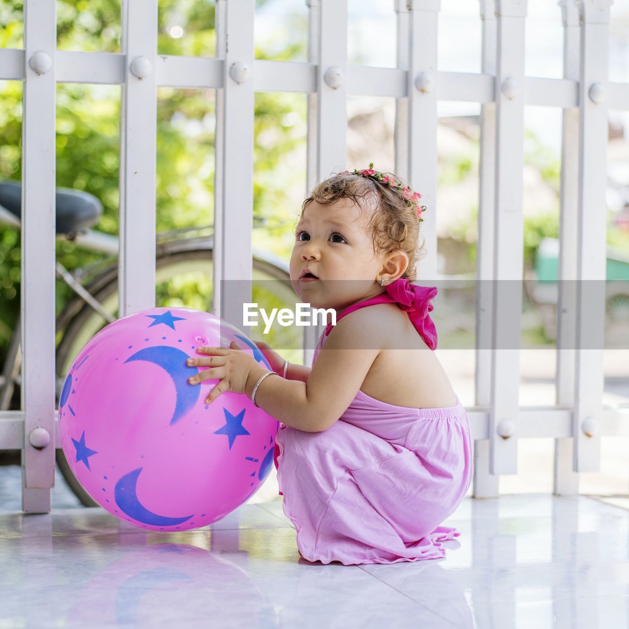 Cute girl playing with ball at porch