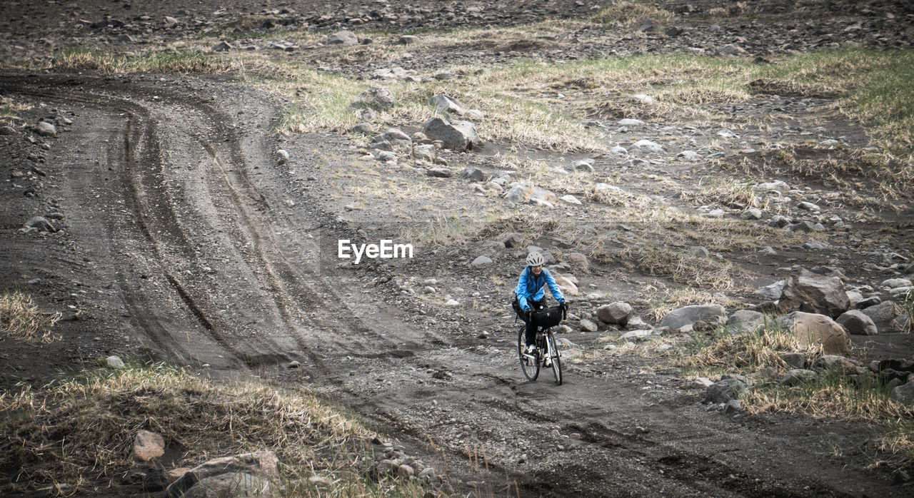 High angle view of person cycling on dirt road