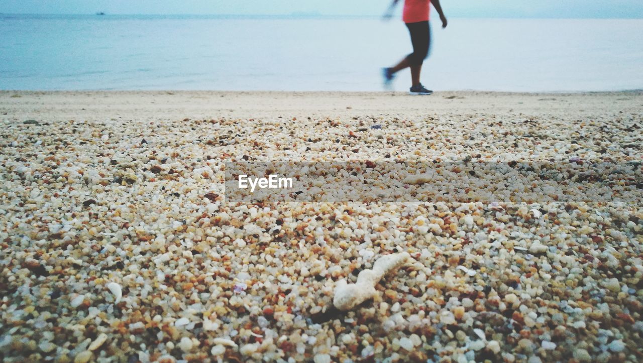 Low section of woman walking on beach