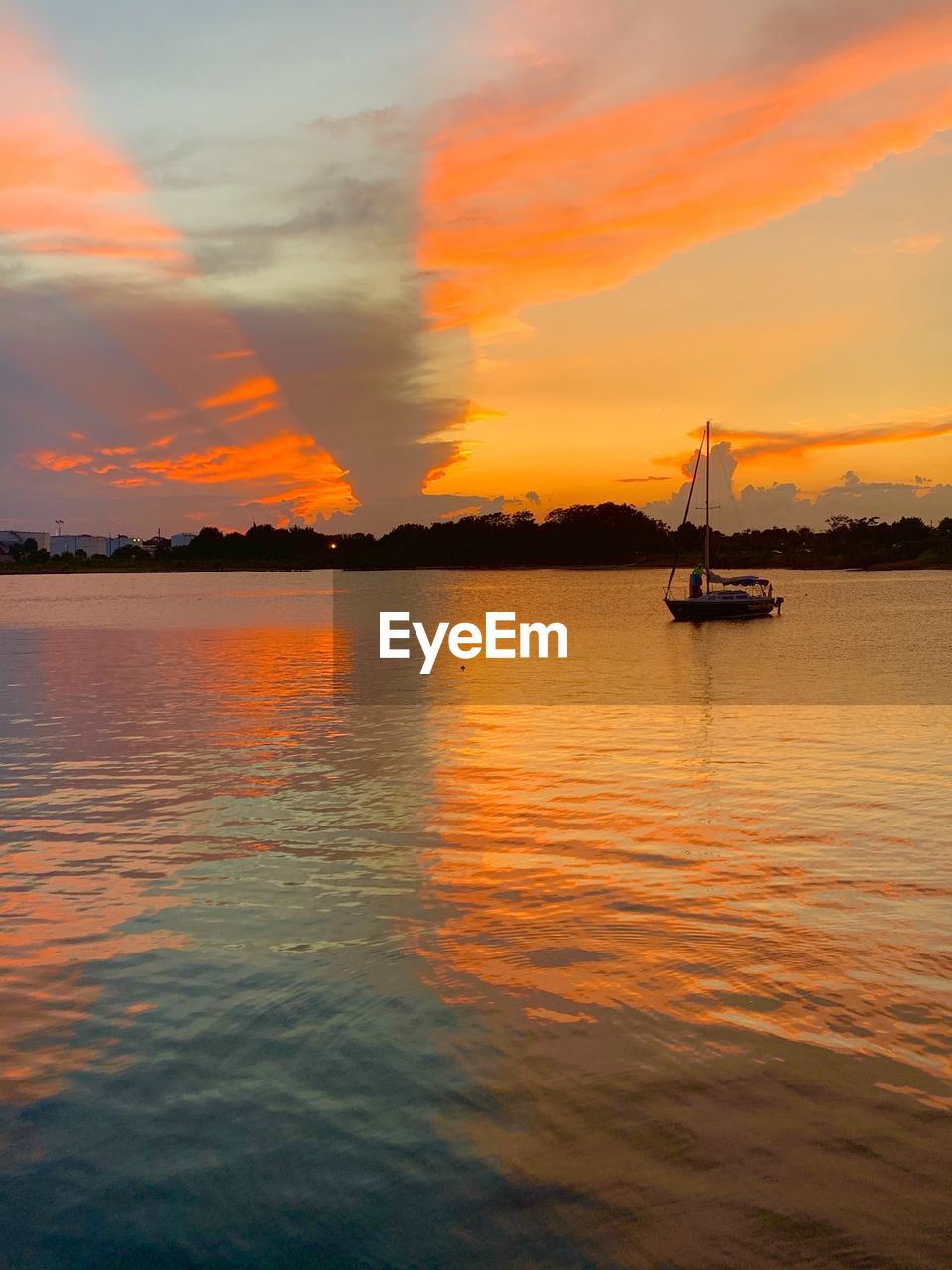 Sailboats in sea against sky during sunset