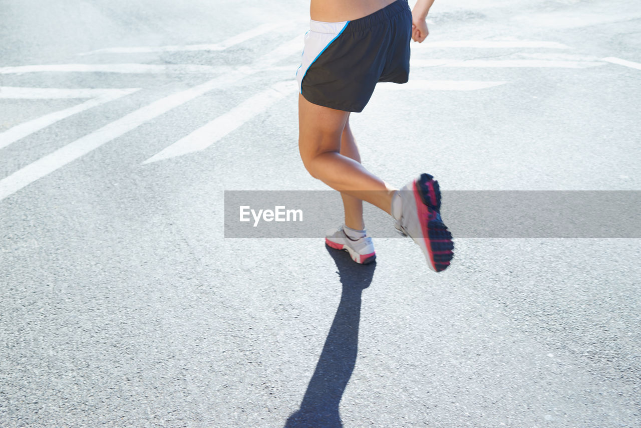 low section of woman walking on street