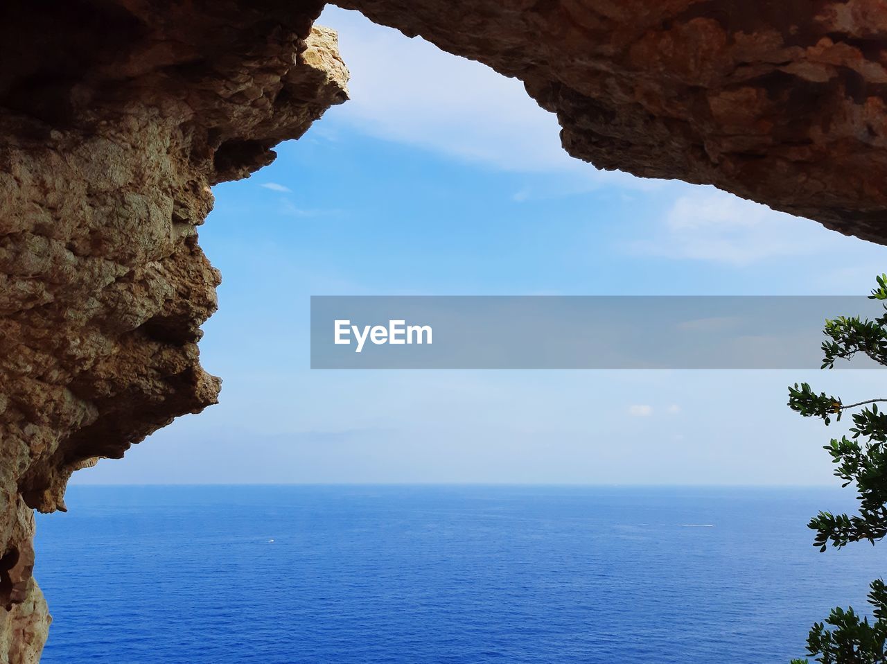 Rock formation in sea against sky
