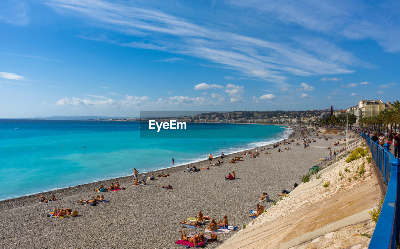 PEOPLE ON BEACH AGAINST BLUE SKY