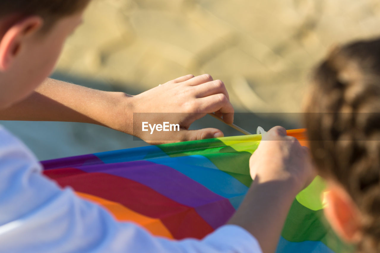 Brother and sister collect a kite in nature close up.