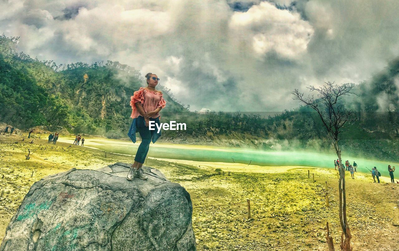 MAN STANDING ON GOLF COURSE AGAINST SKY