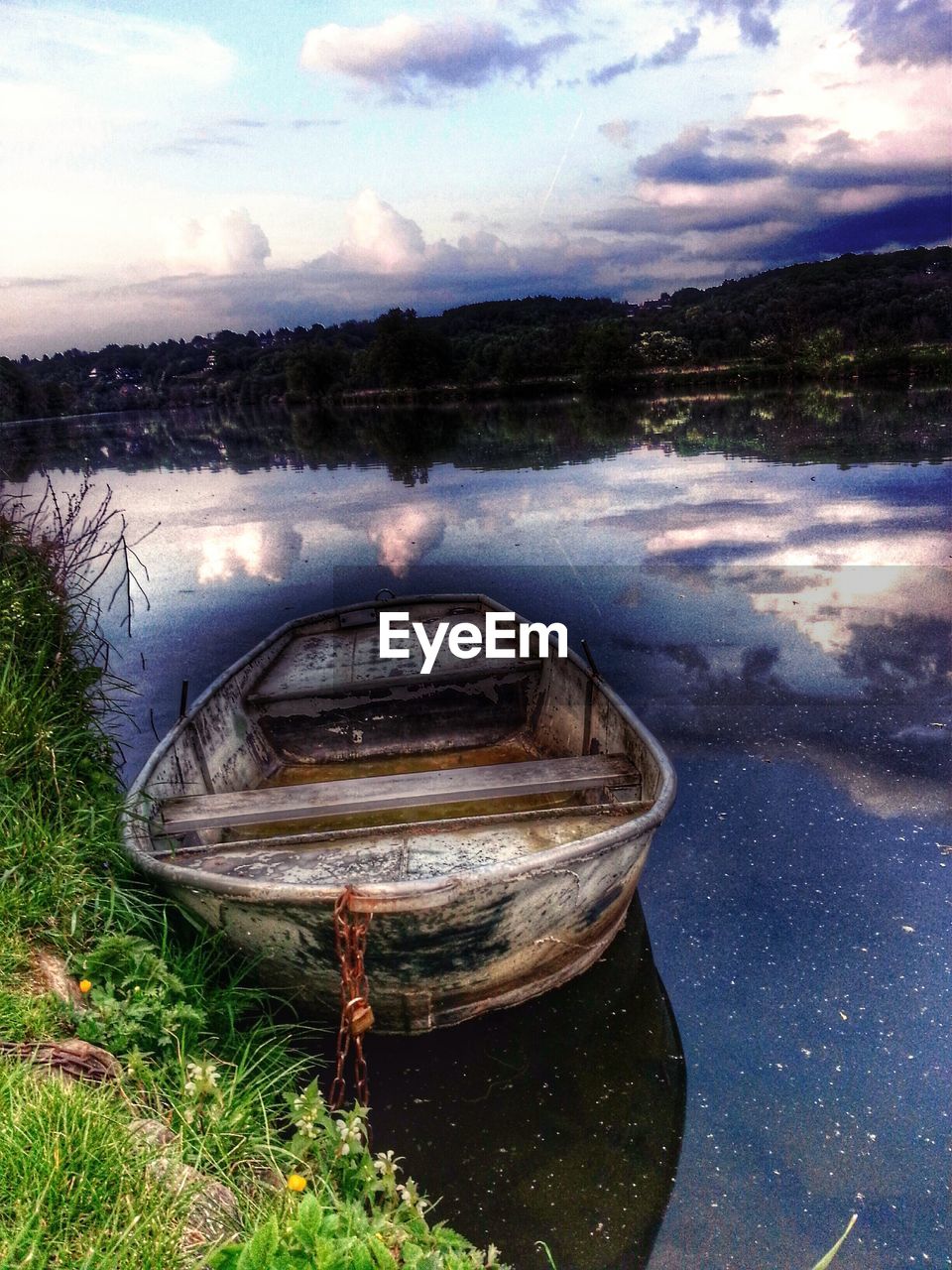 VIEW OF BOATS IN LAKE AGAINST CLOUDY SKY