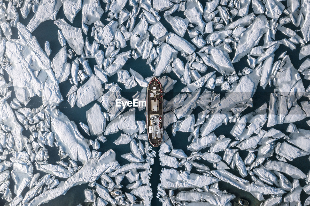 Aerial view of ship amidst glacier in sea