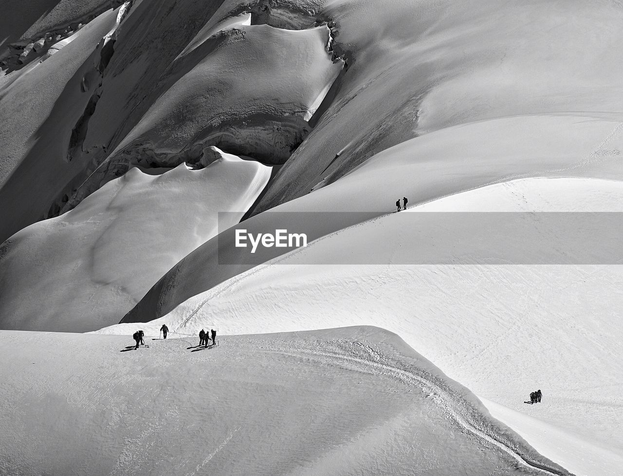 Aerial view of silhouette hikers on snowcapped mountain