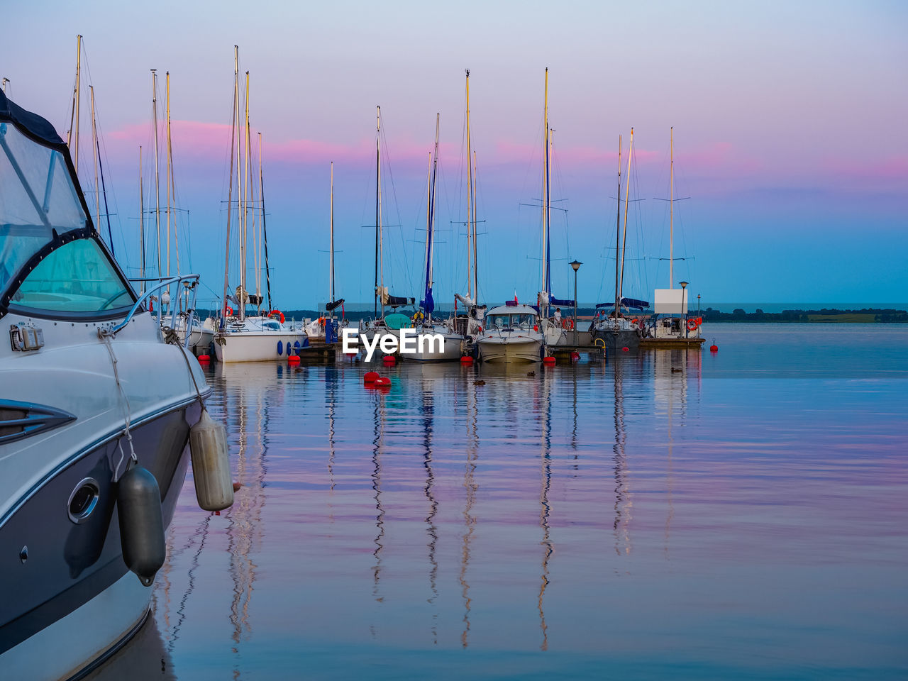 water, transportation, nautical vessel, mode of transportation, sea, sky, vehicle, reflection, marina, boat, moored, sailboat, dock, ship, nature, sunset, beauty in nature, pole, tranquility, no people, harbor, travel, watercraft, mast, scenics - nature, tranquil scene, bay, idyllic, outdoors, travel destinations, yacht, boating, dusk, sailing