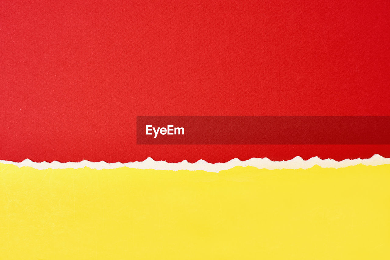 Torn ripped paper edge with copy space, red and yellow color background