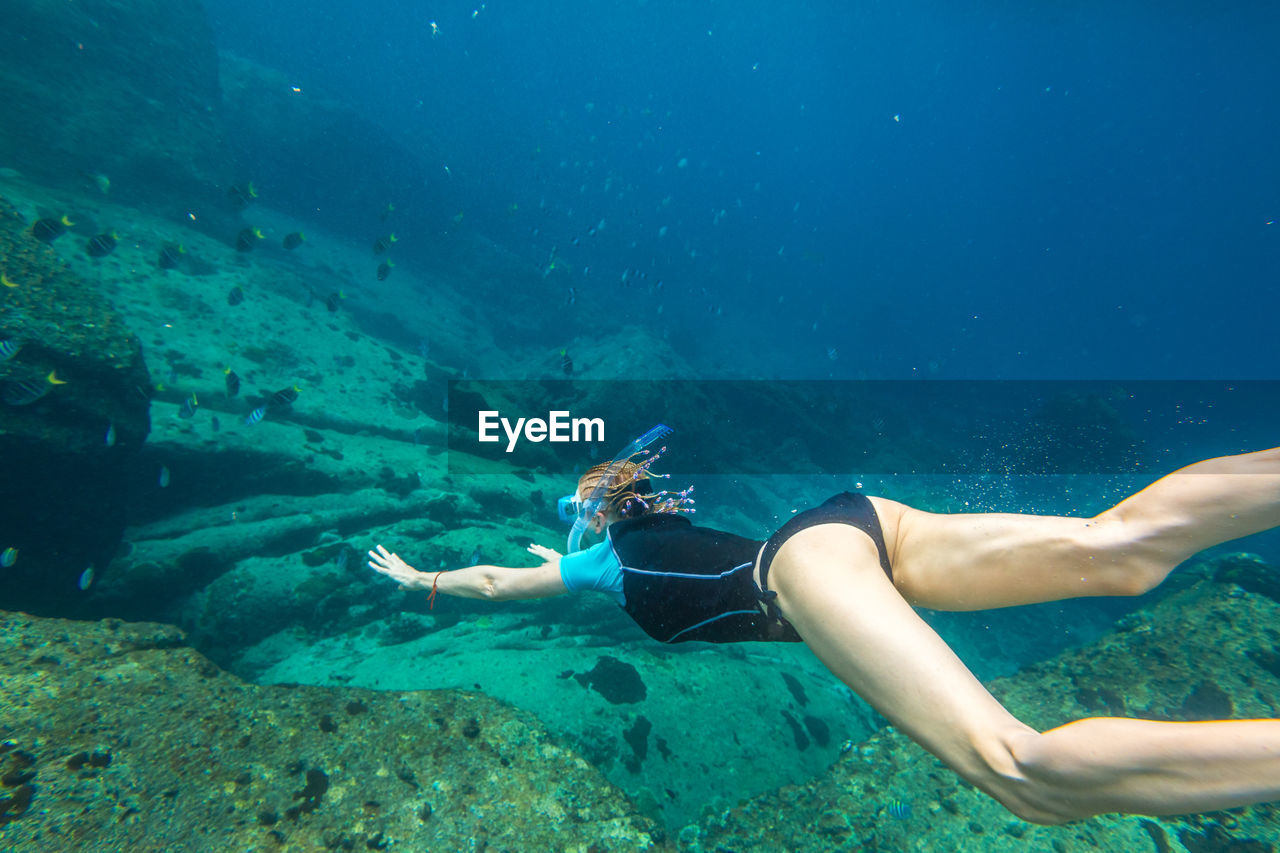 Woman snorkeling over coral reef undersea