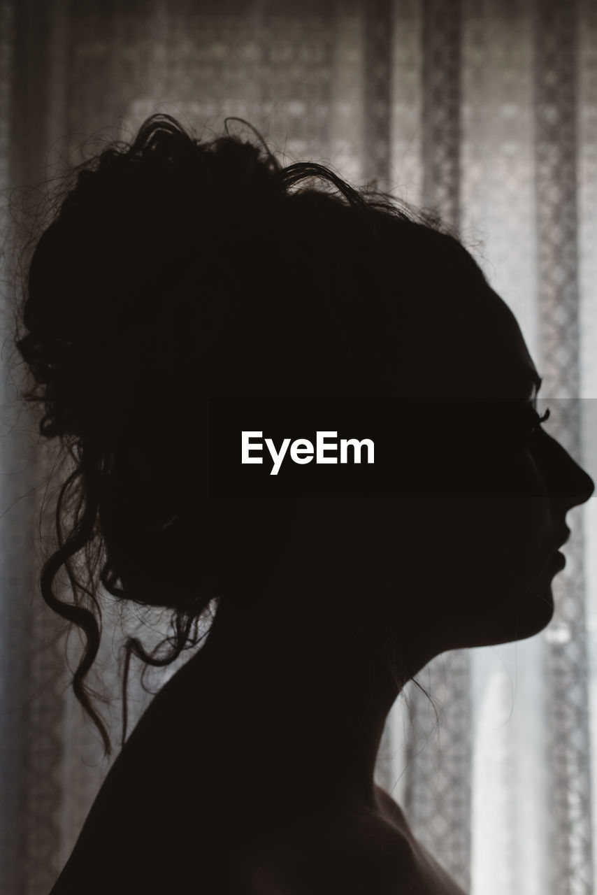 Side view of silhouette young woman at home
