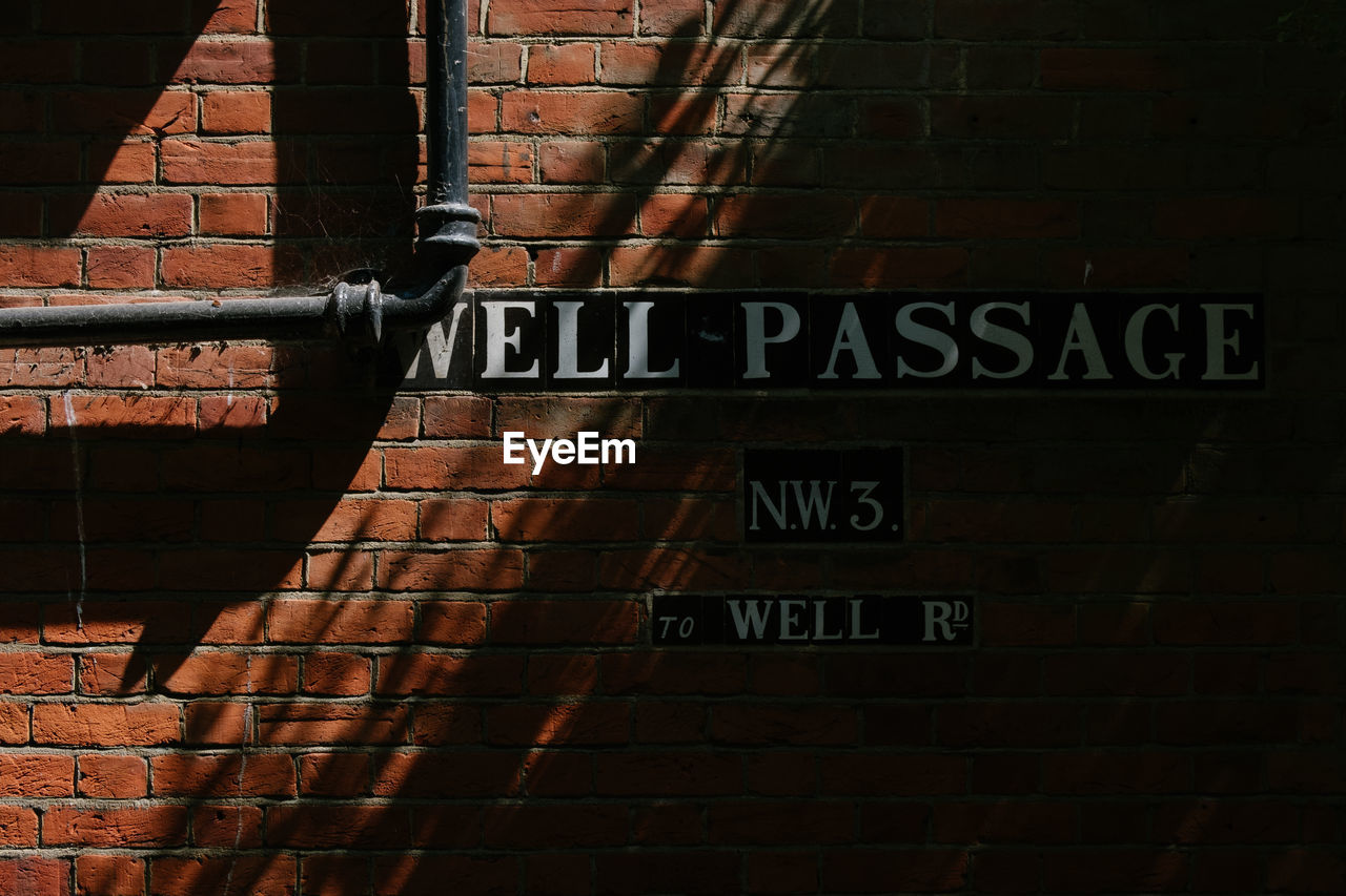 Text and pipe on brick wall