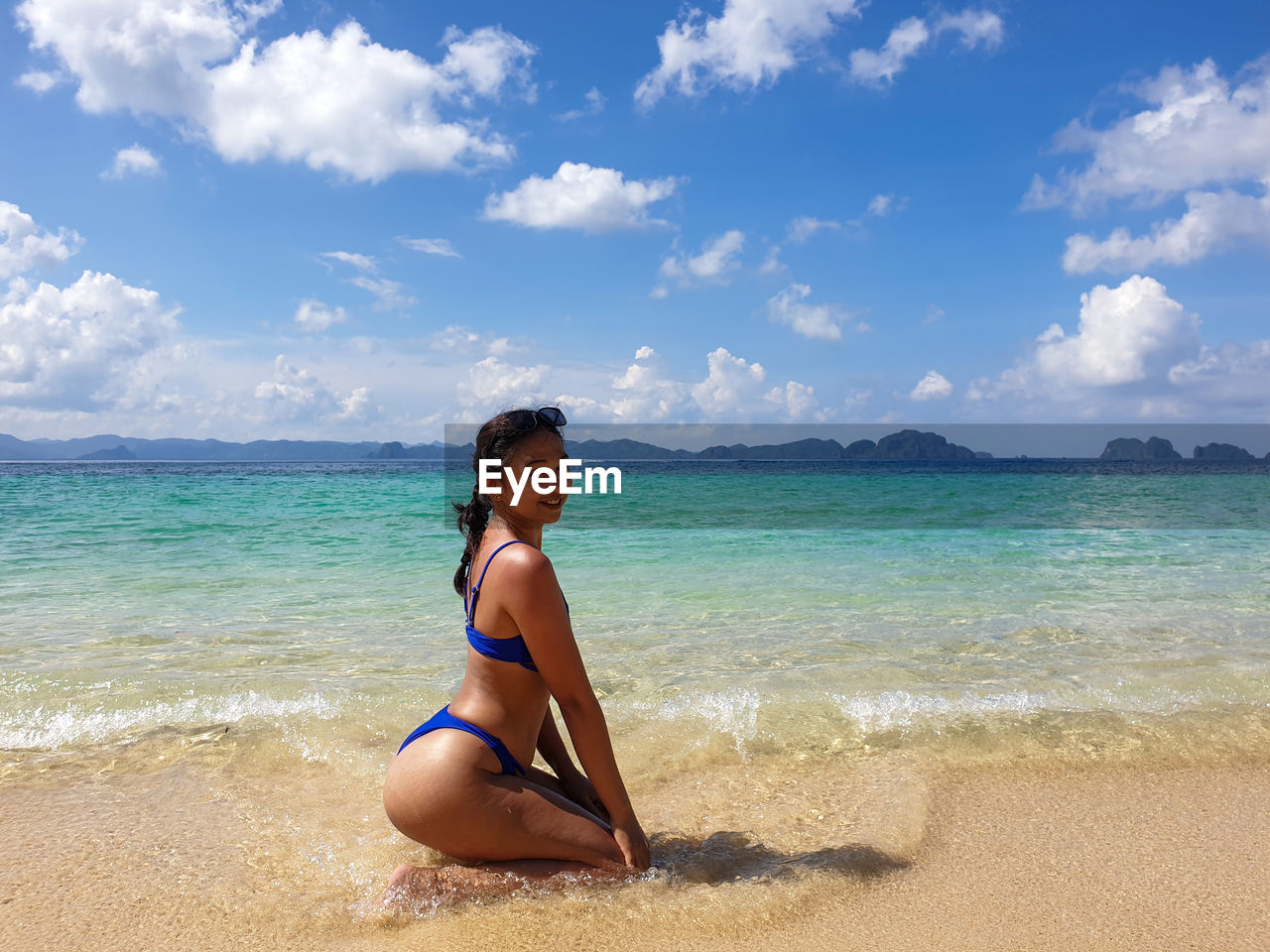 Portrait of smiling woman sitting at beach