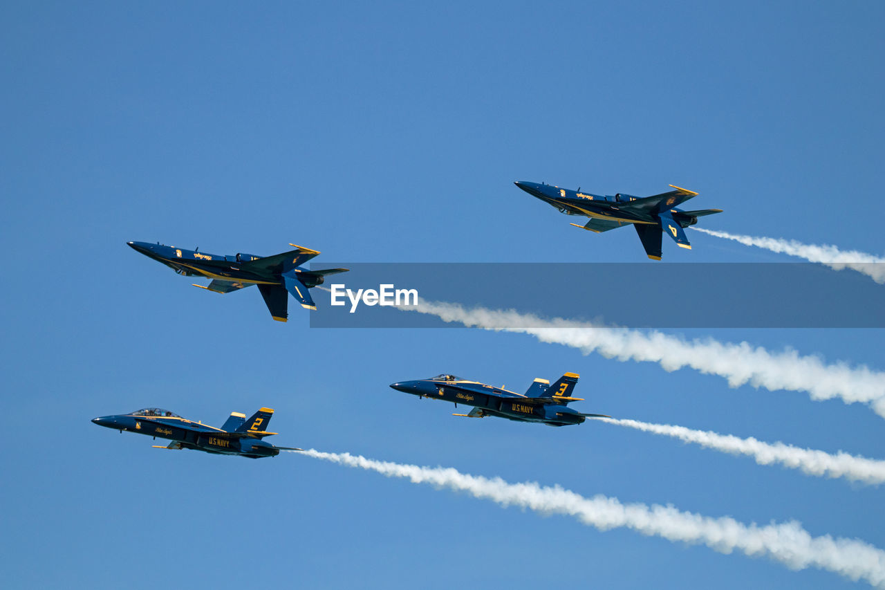 LOW ANGLE VIEW OF AIRSHOW AGAINST BLUE SKY