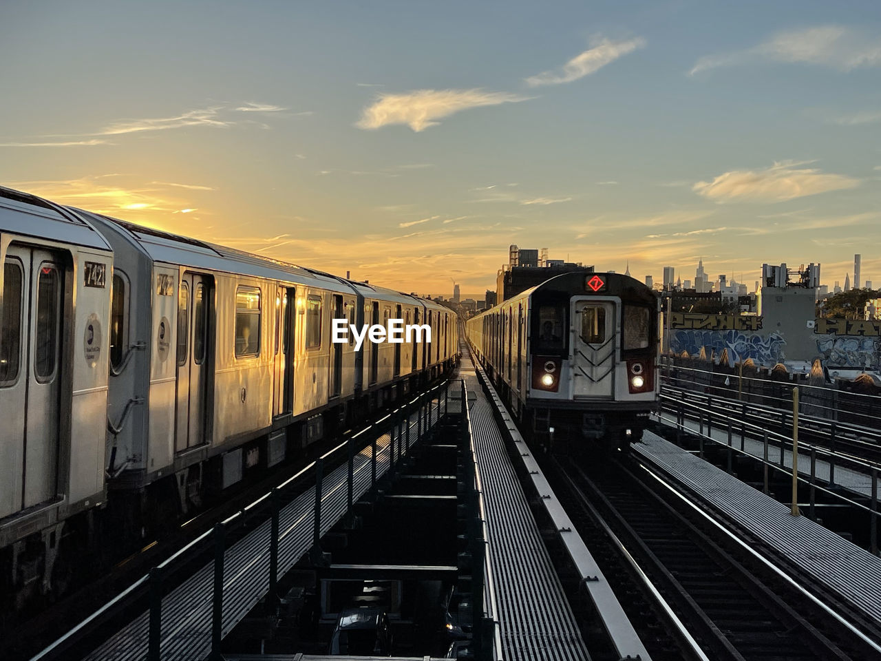 Train at railroad station against sky during sunset