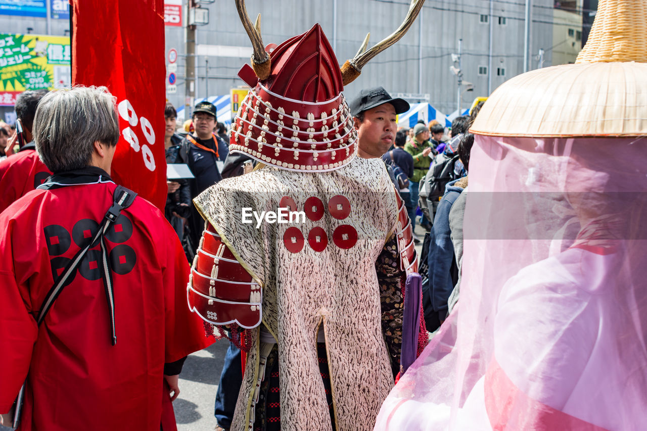 REAR VIEW OF PEOPLE WALKING IN TRADITIONAL CLOTHING