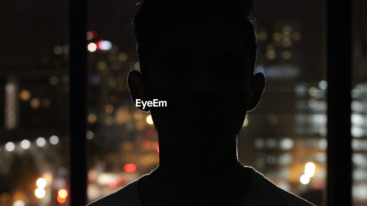 Portrait of a teenage boy against blurred lights