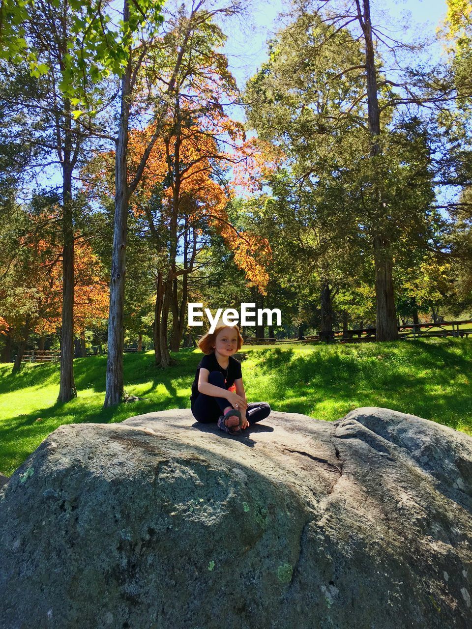 WOMAN SITTING IN PARK DURING AUTUMN