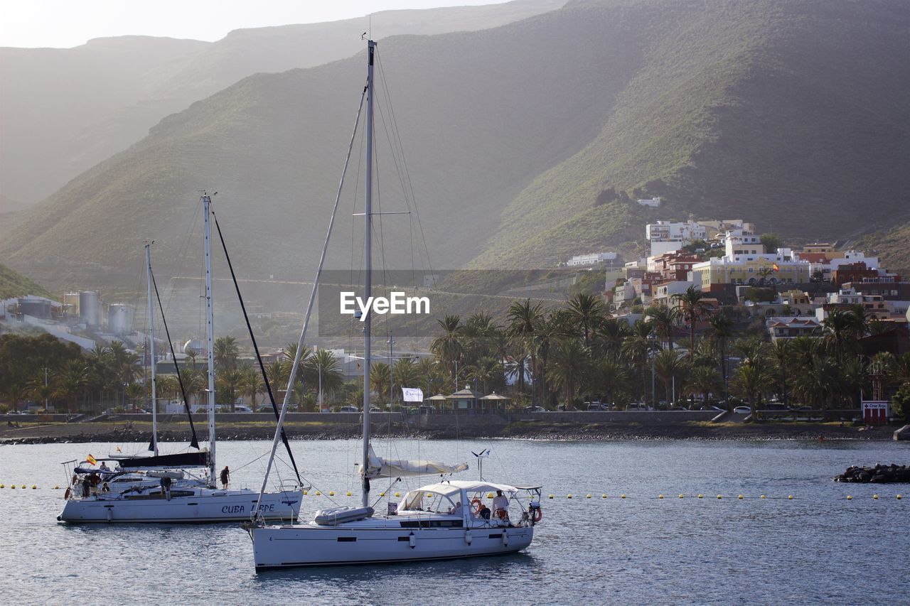 Sailboats in sea against canary island la gomera