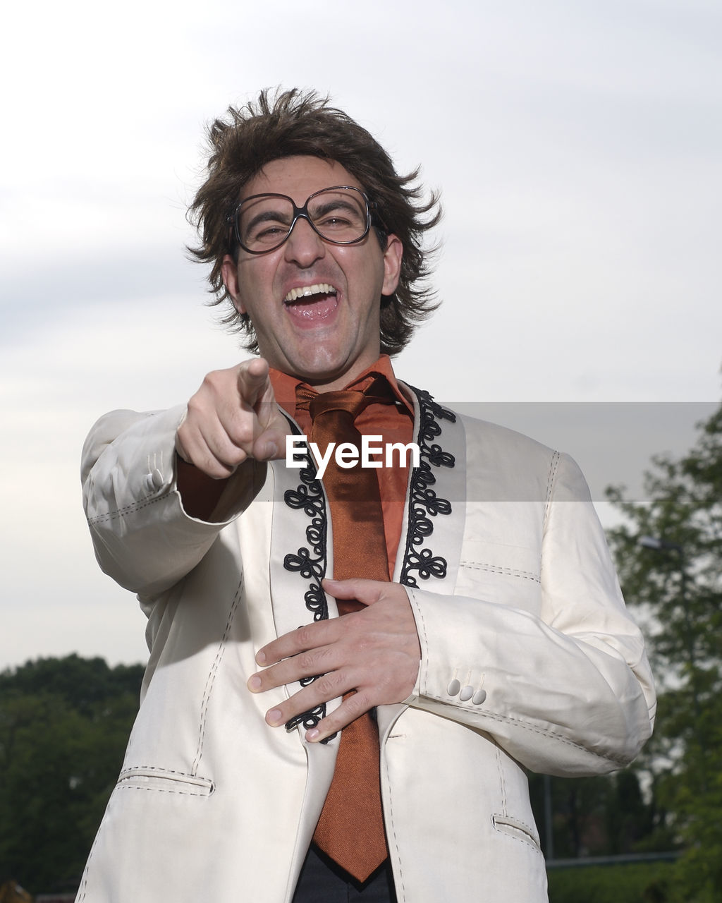PORTRAIT OF SMILING MAN STANDING AGAINST SKY