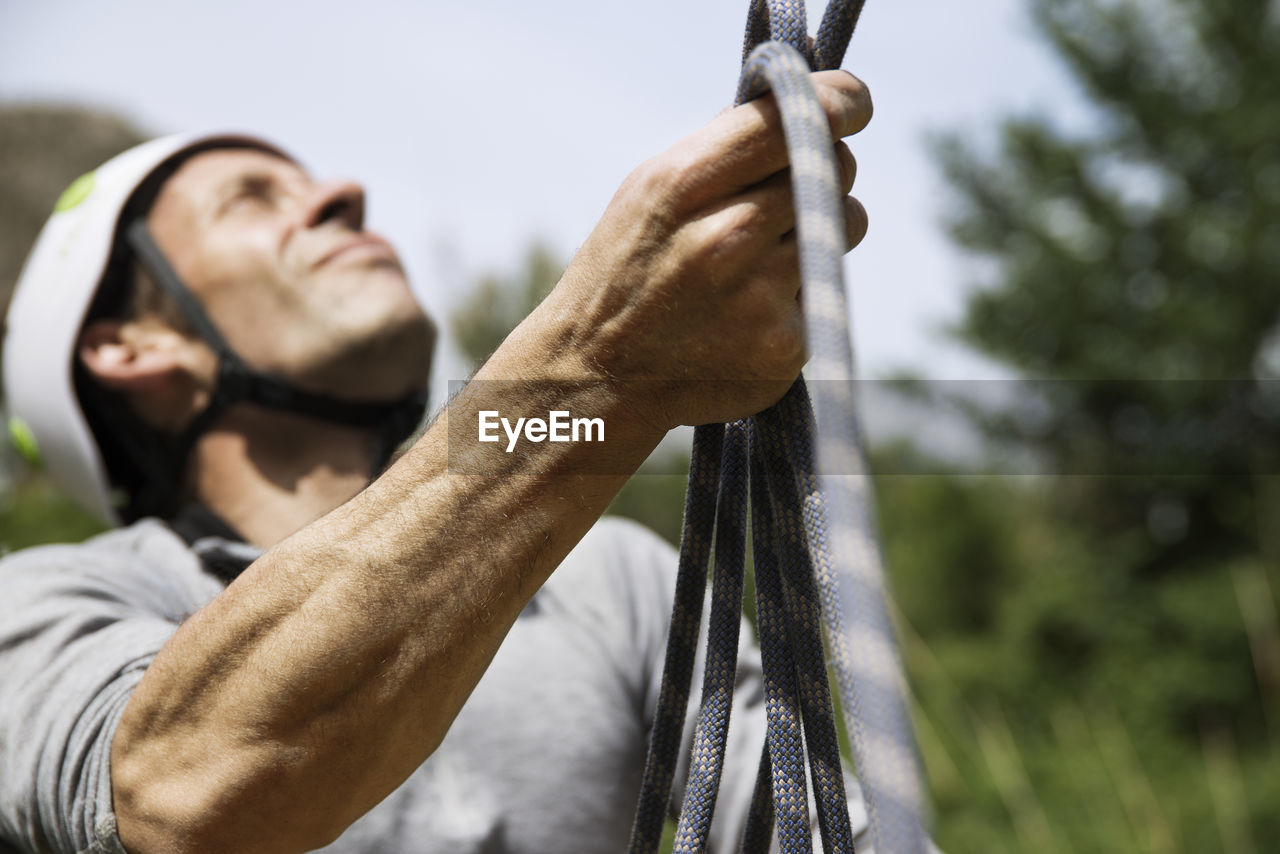 Close-up of mature man holding climbing rope
