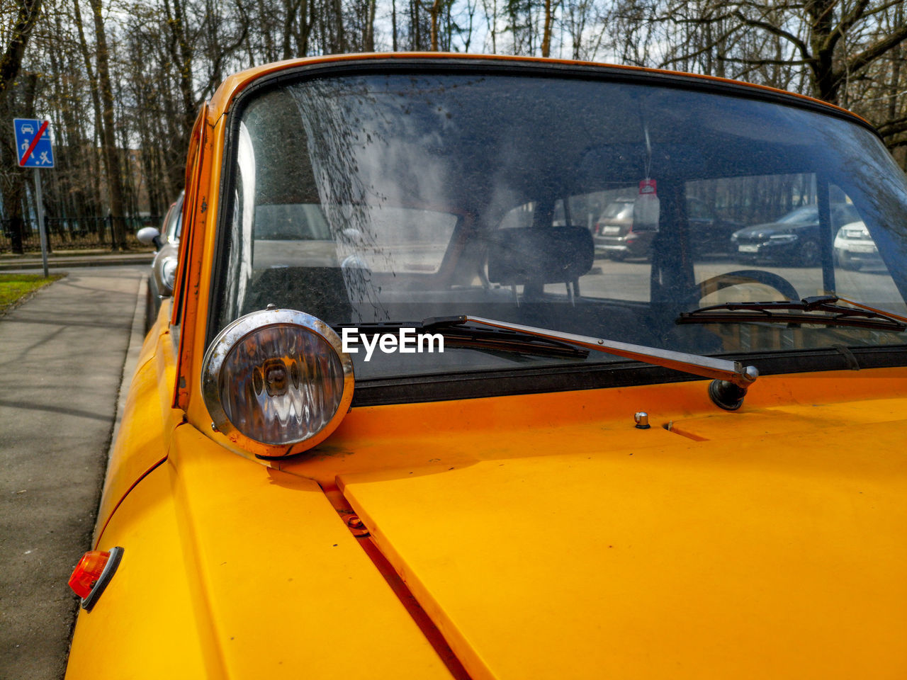 REFLECTION OF YELLOW CAR ON MIRROR