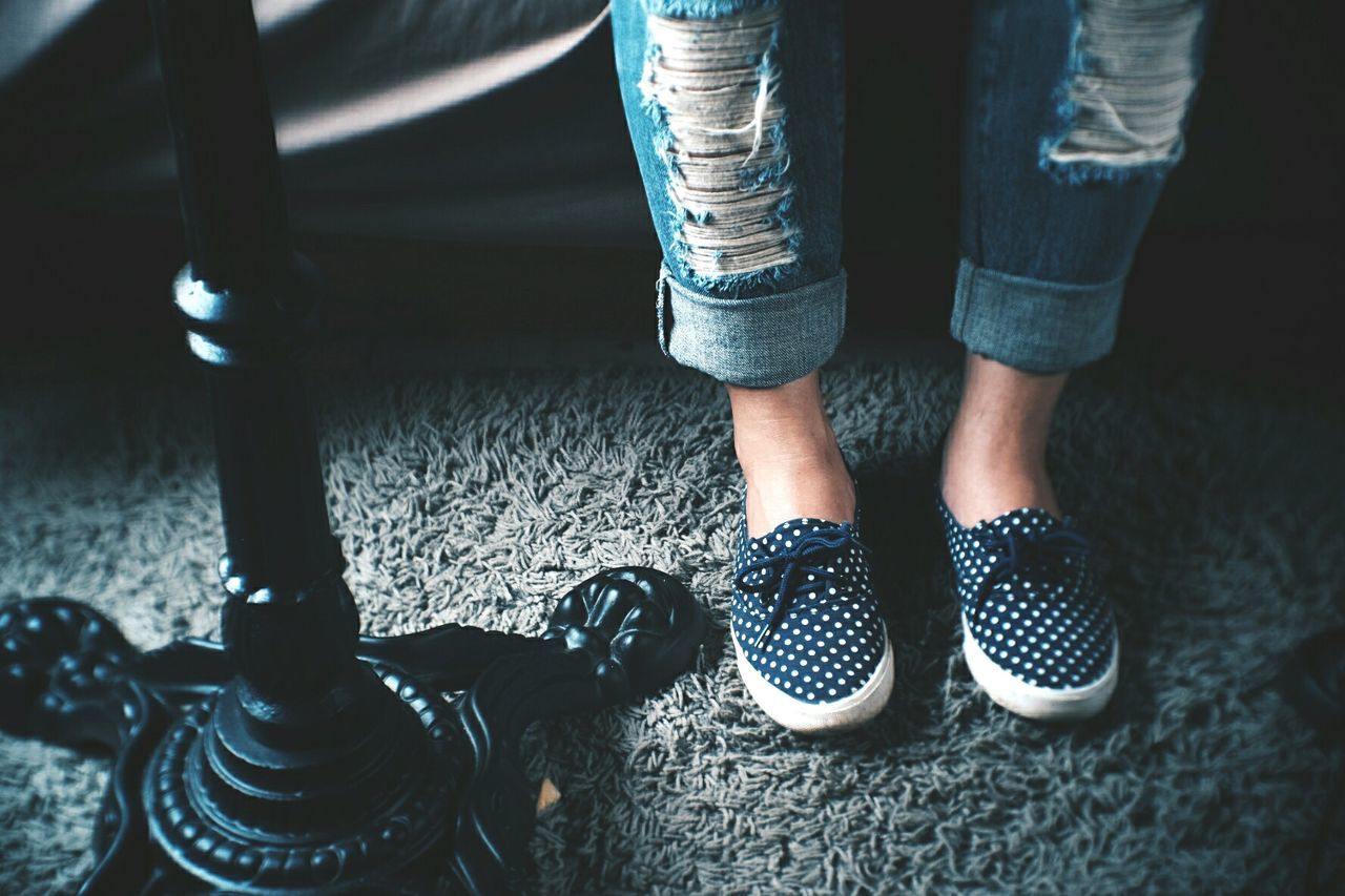 Low section of woman standing on rug while wearing shoes