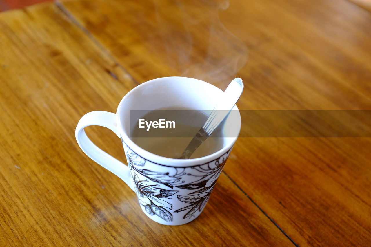 High angle view of coffee cup on wooden table